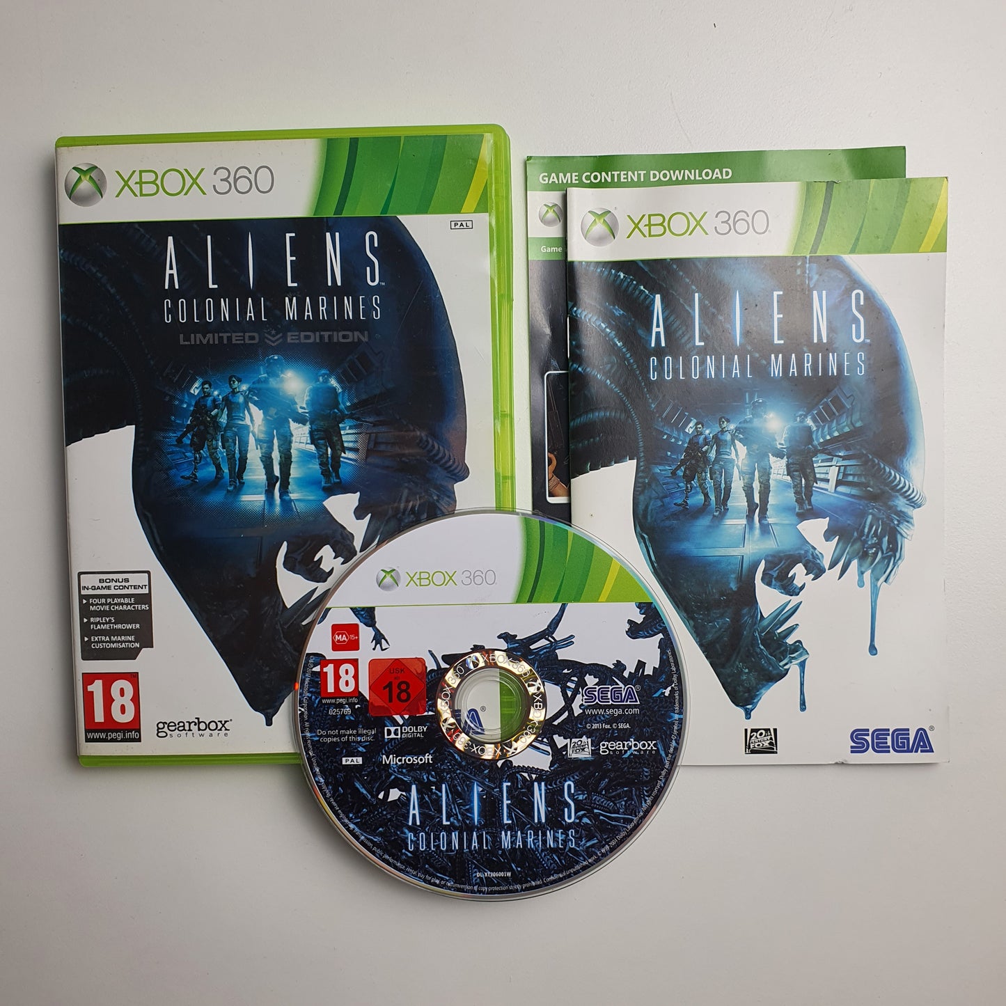Xbox 360 game case with Alien: Colonial Marines and its disc on a grey background