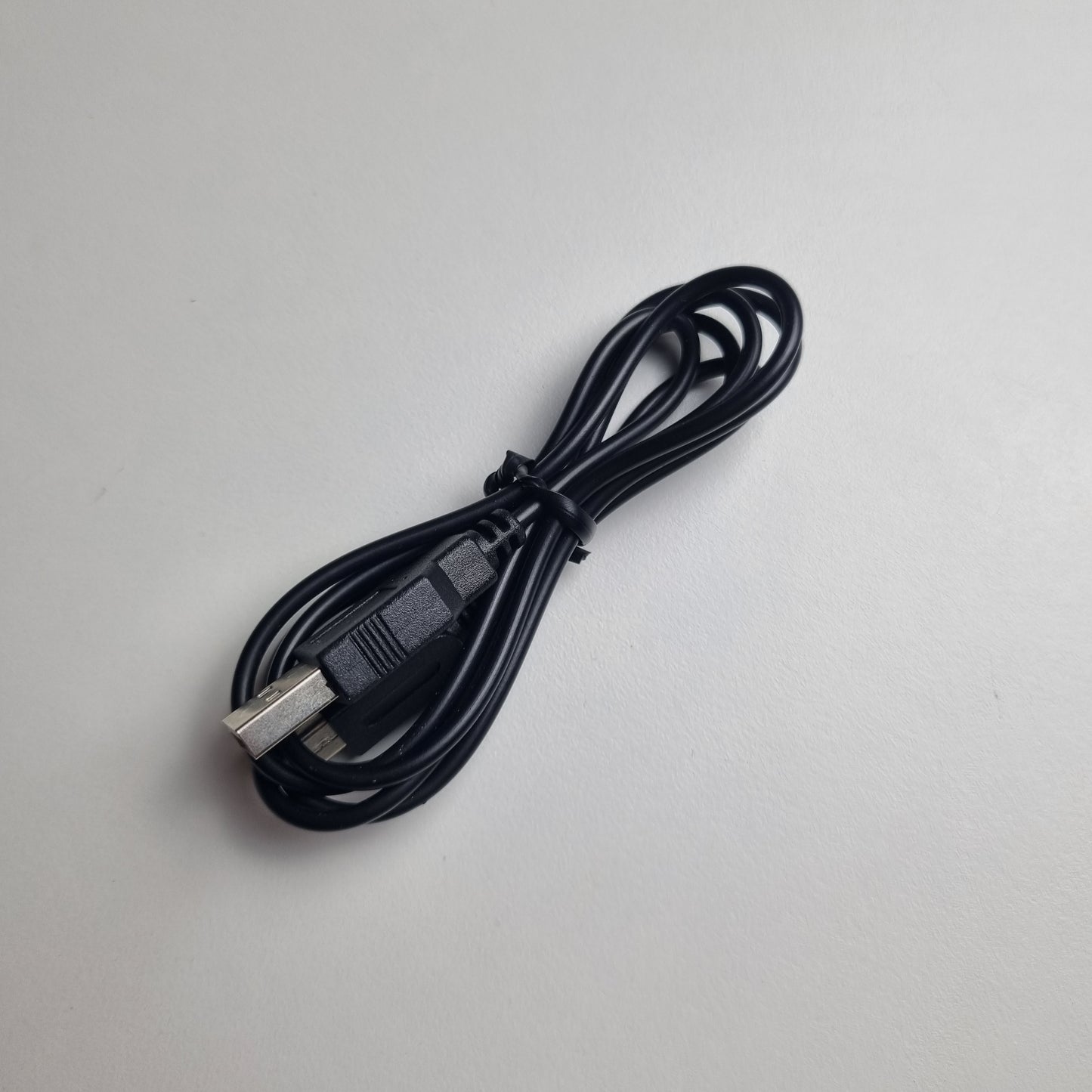 Black USB cable on a light gray background