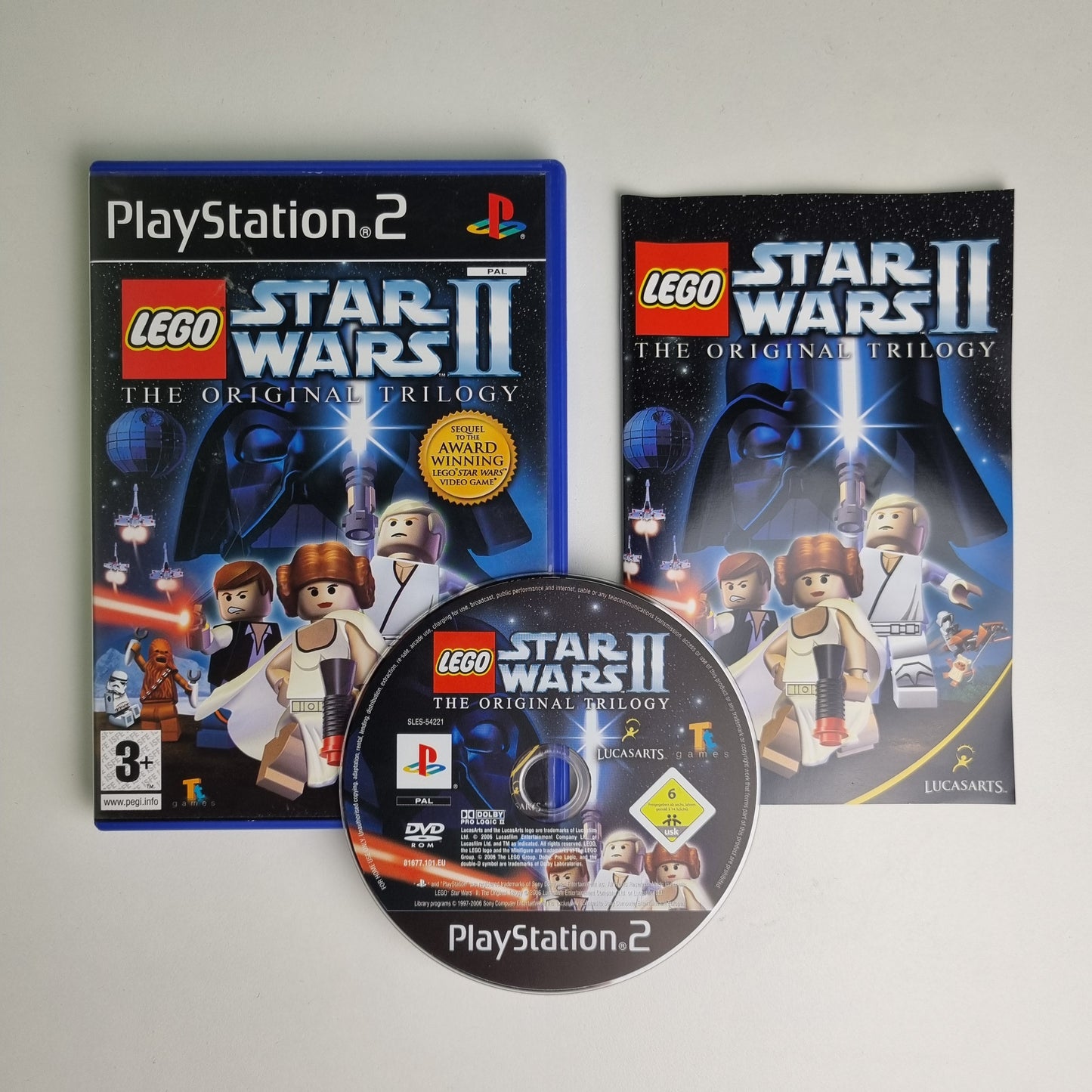 Official Sony PlayStation 2 game case and disc of LEGO Star Wars II on a gray background