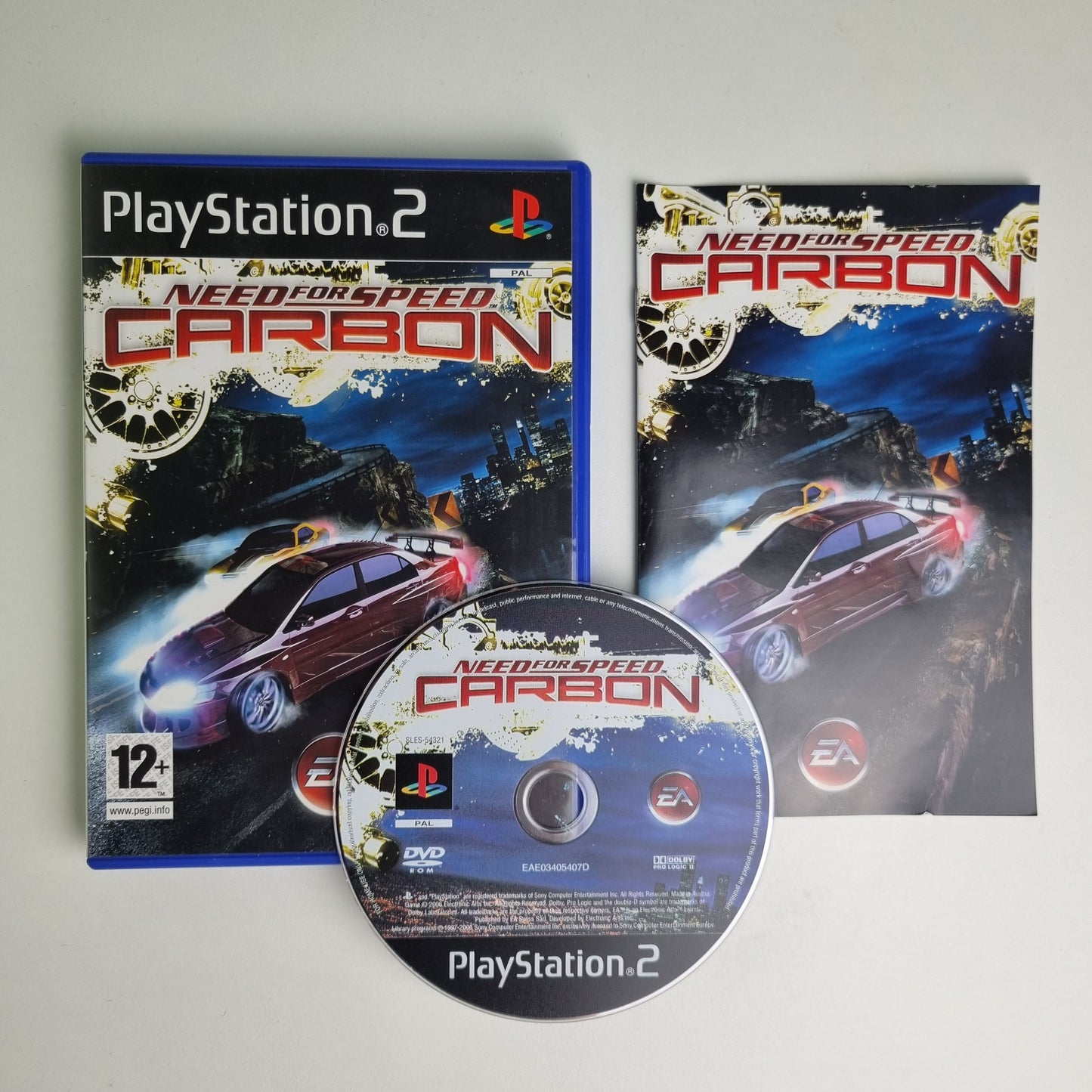 PlayStation 2 game 'Need for Speed Carbon' with case, manual and disc on a light gray background