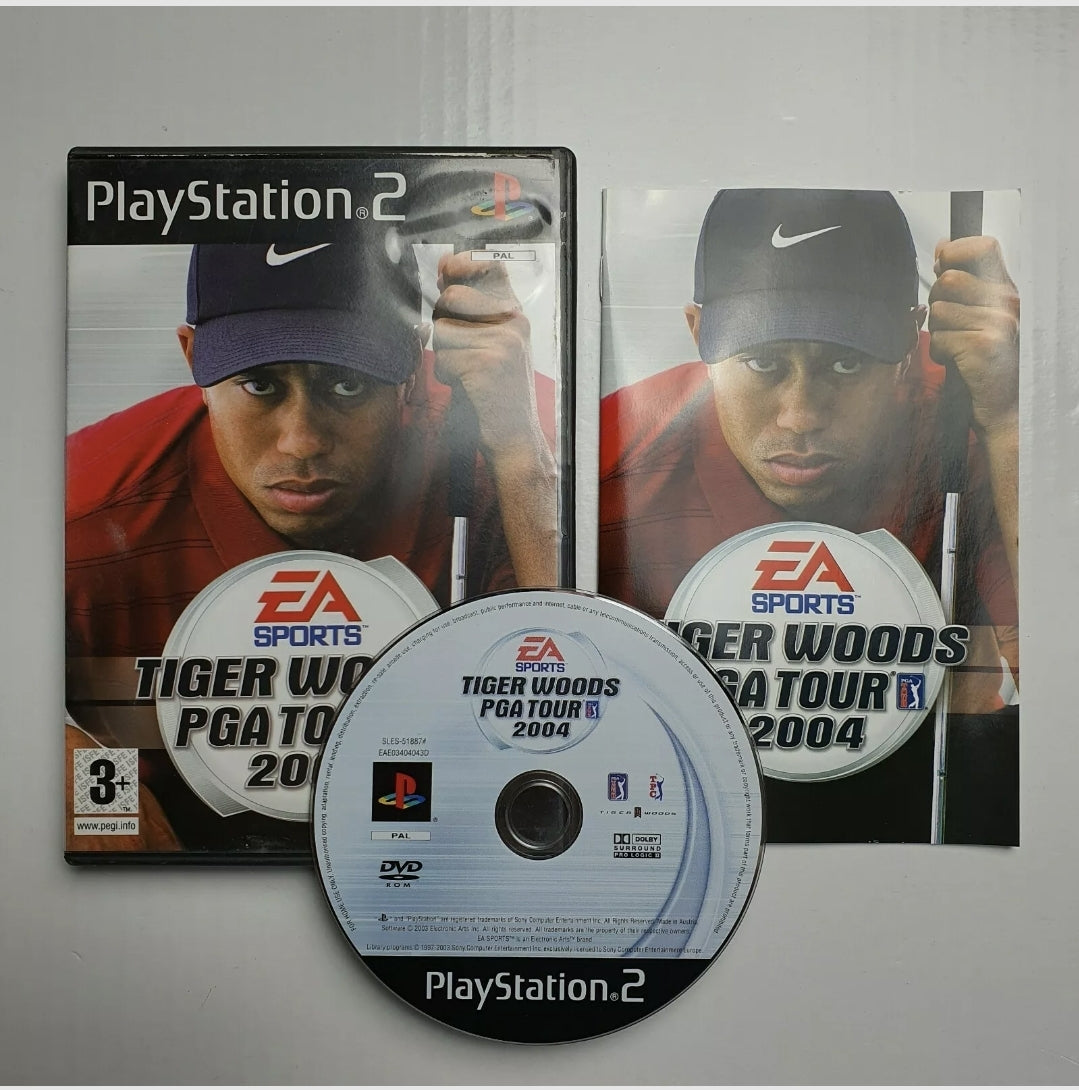 A PlayStation 2 game disc, case and manual for 'Tiger Woods PGA Tour 2004' with a graphical representation of Tiger Woods on the cover.