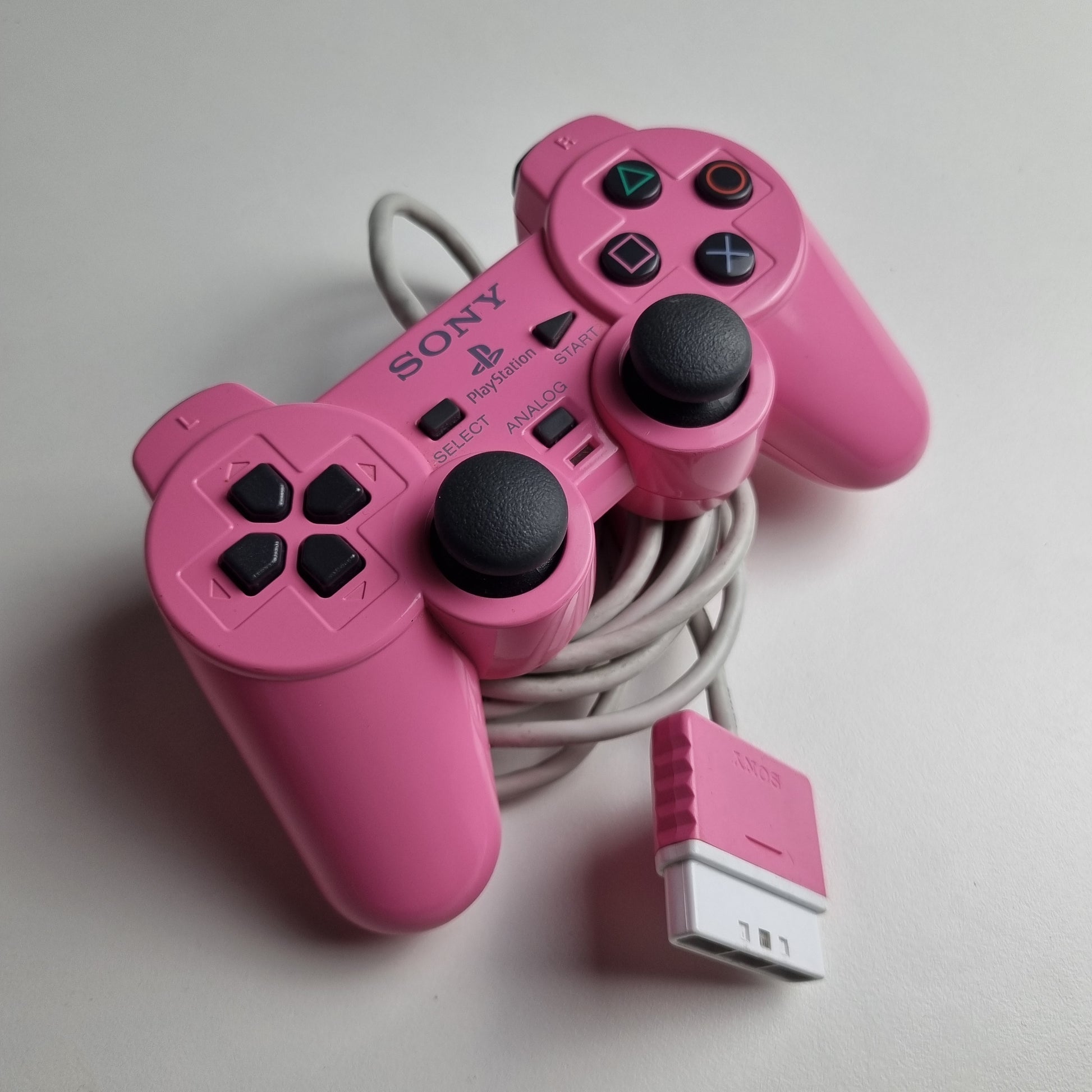 Official Sony PlayStation 2 DualShock refurbished pink wired controller on a light gray background