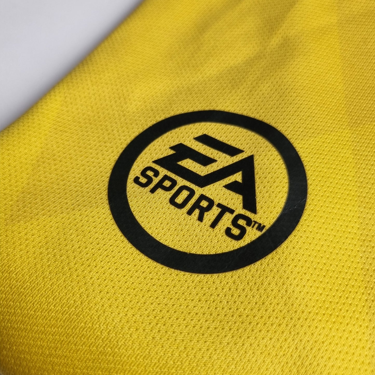 Yellow fabric with a black logo and text on a grey background