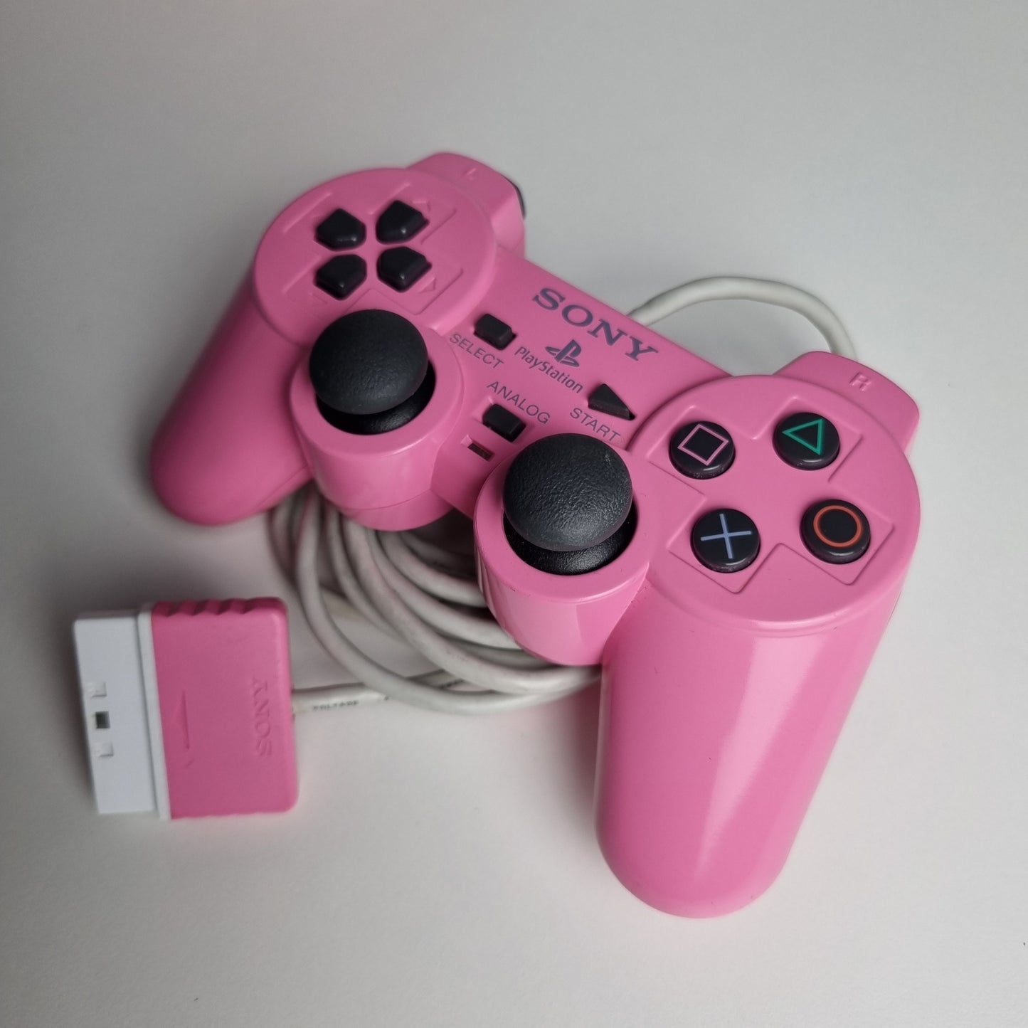 Official Sony PlayStation 2 DualShock refurbished pink wired controller on a light gray background