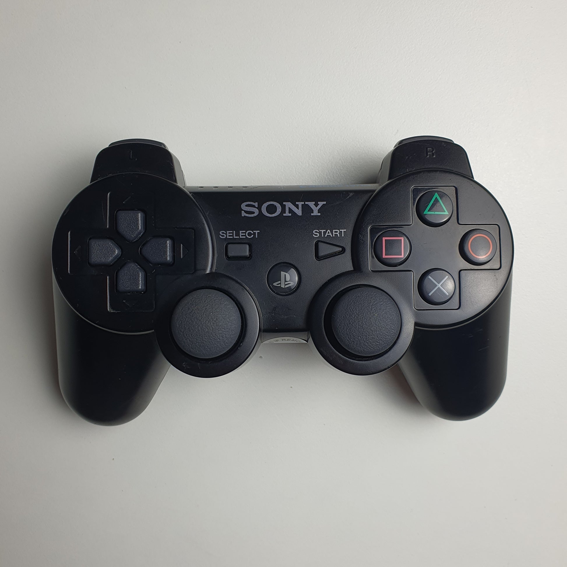 Black PlayStation 3 controller with Sony logo on a white background