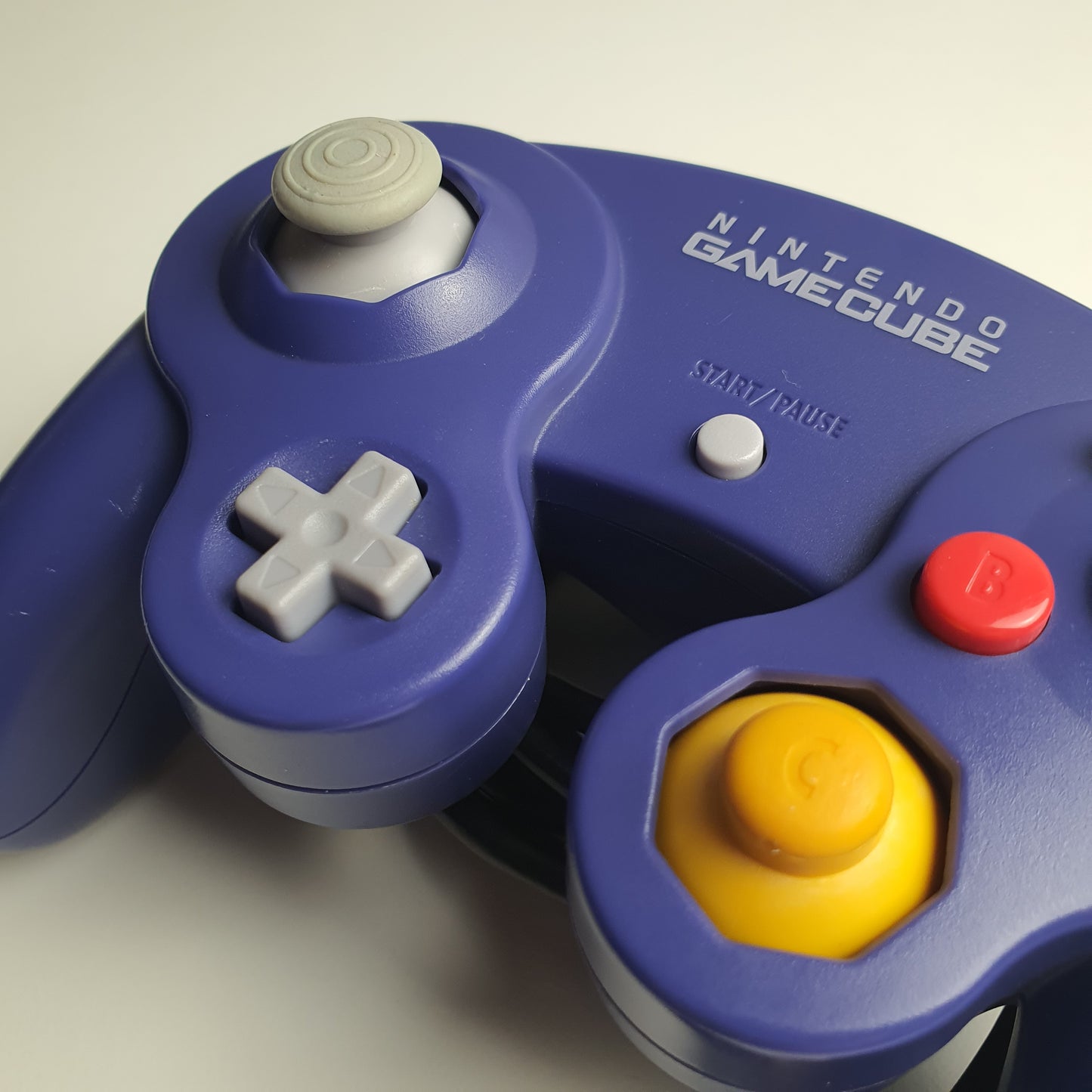 Close-up of a Nintendo GameCube controller on a light background