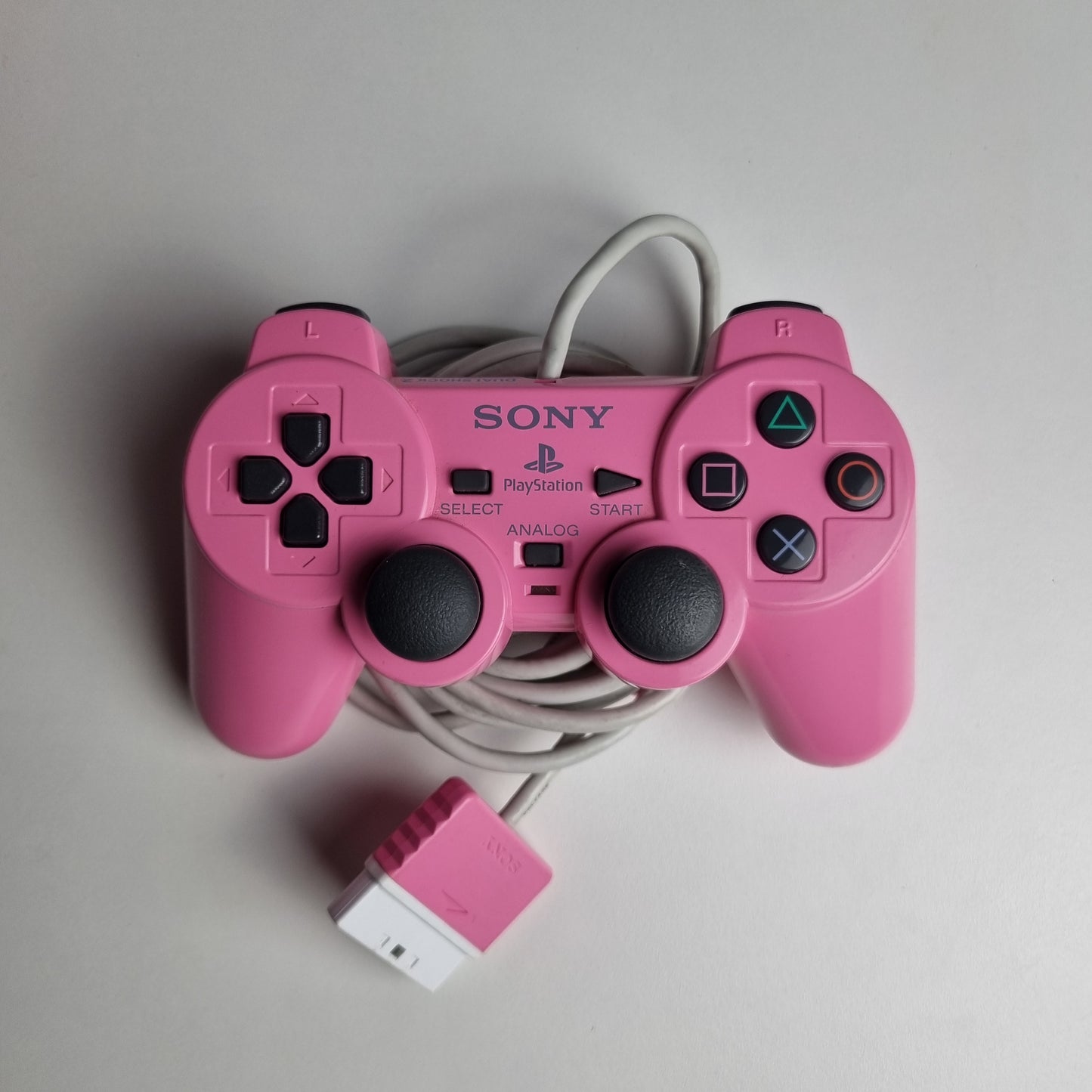 Official Sony PlayStation 2 DualShock refurbished pink wired controller on a light gray background