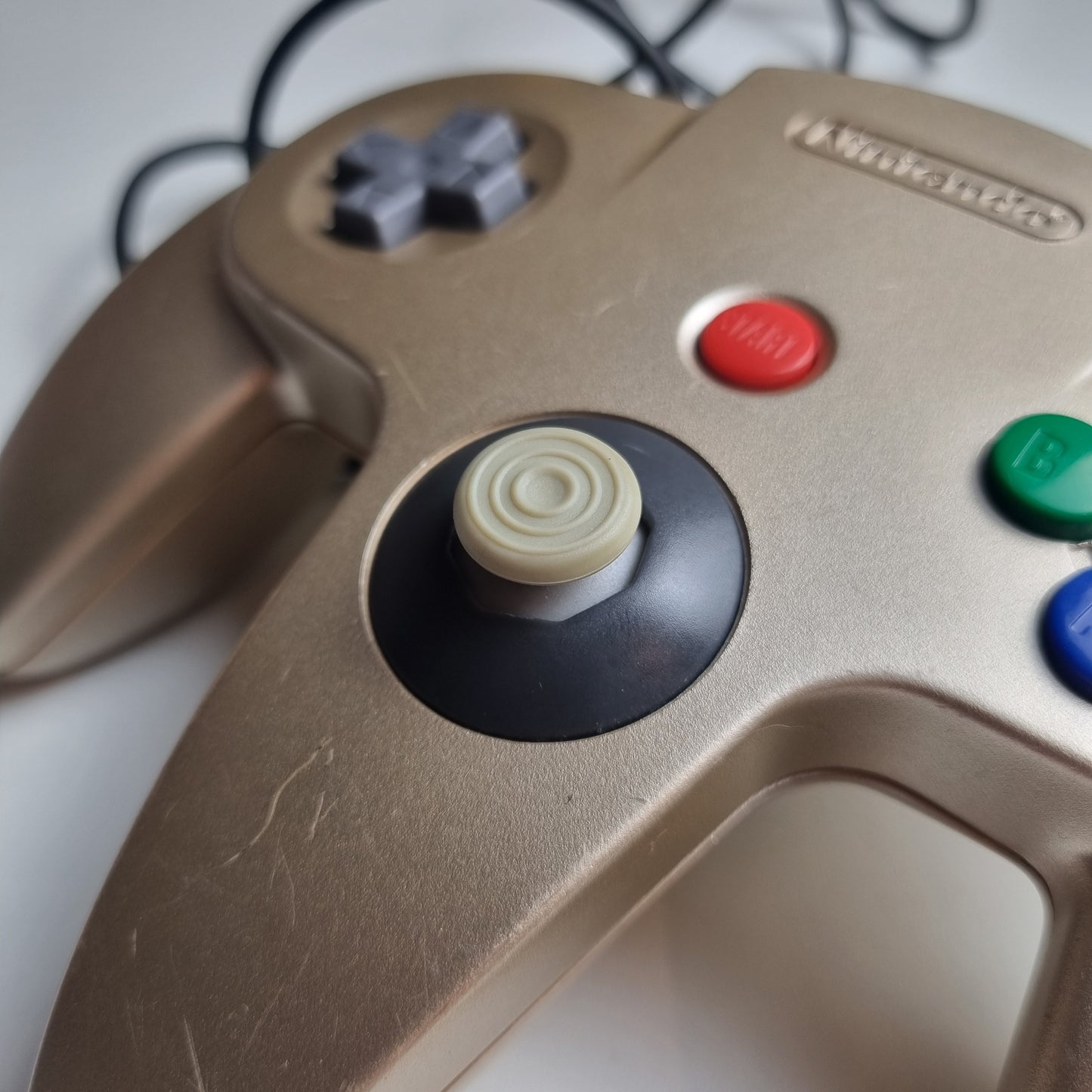 Close-up of a 'GameCube style' analog stick on a refurbished modified gold Nintendo 64 controller.