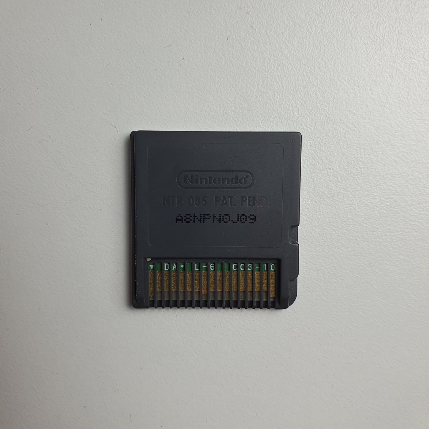 Back of a Nintendo DS game cartridge on a light grey background
