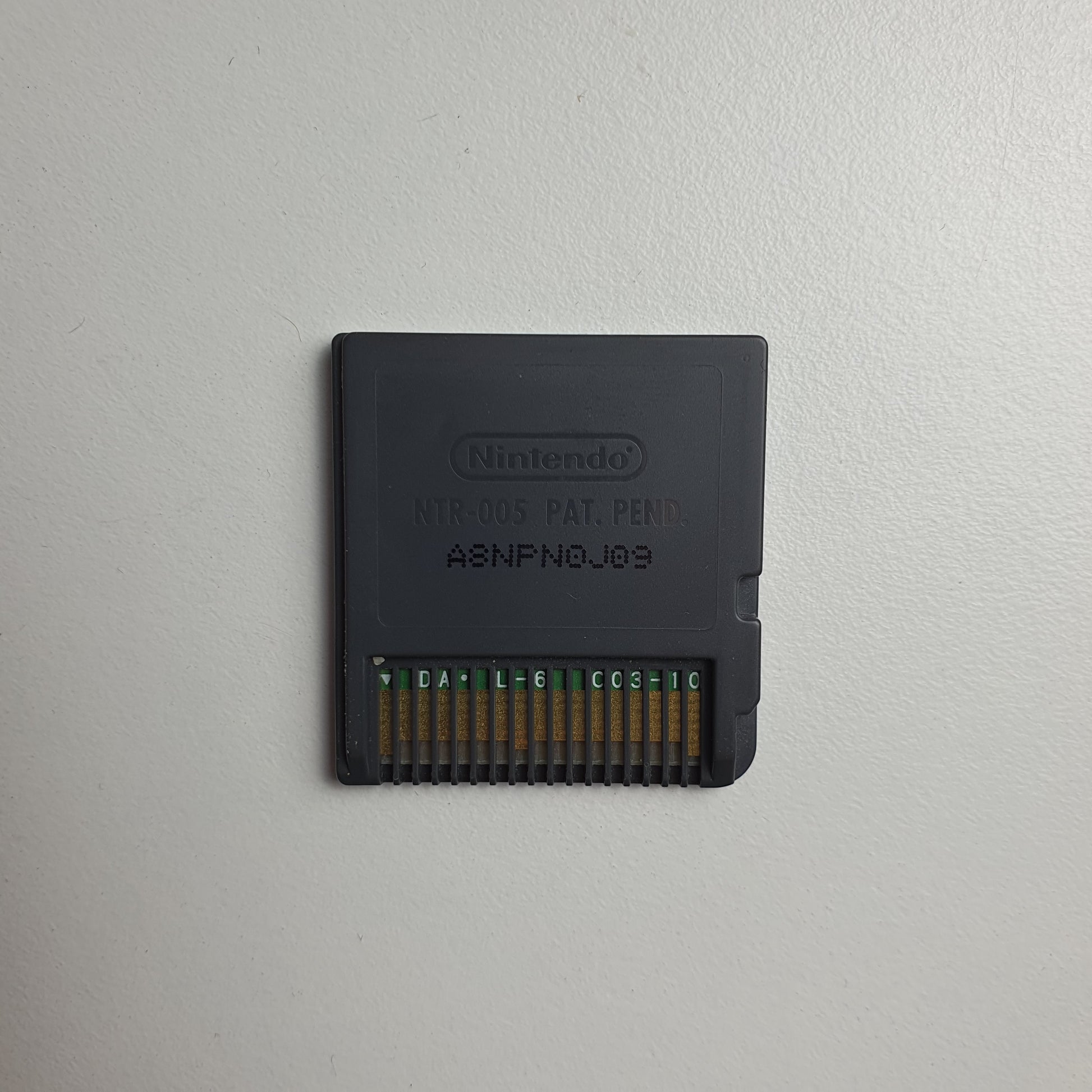Back of a Nintendo DS game cartridge on a light grey background