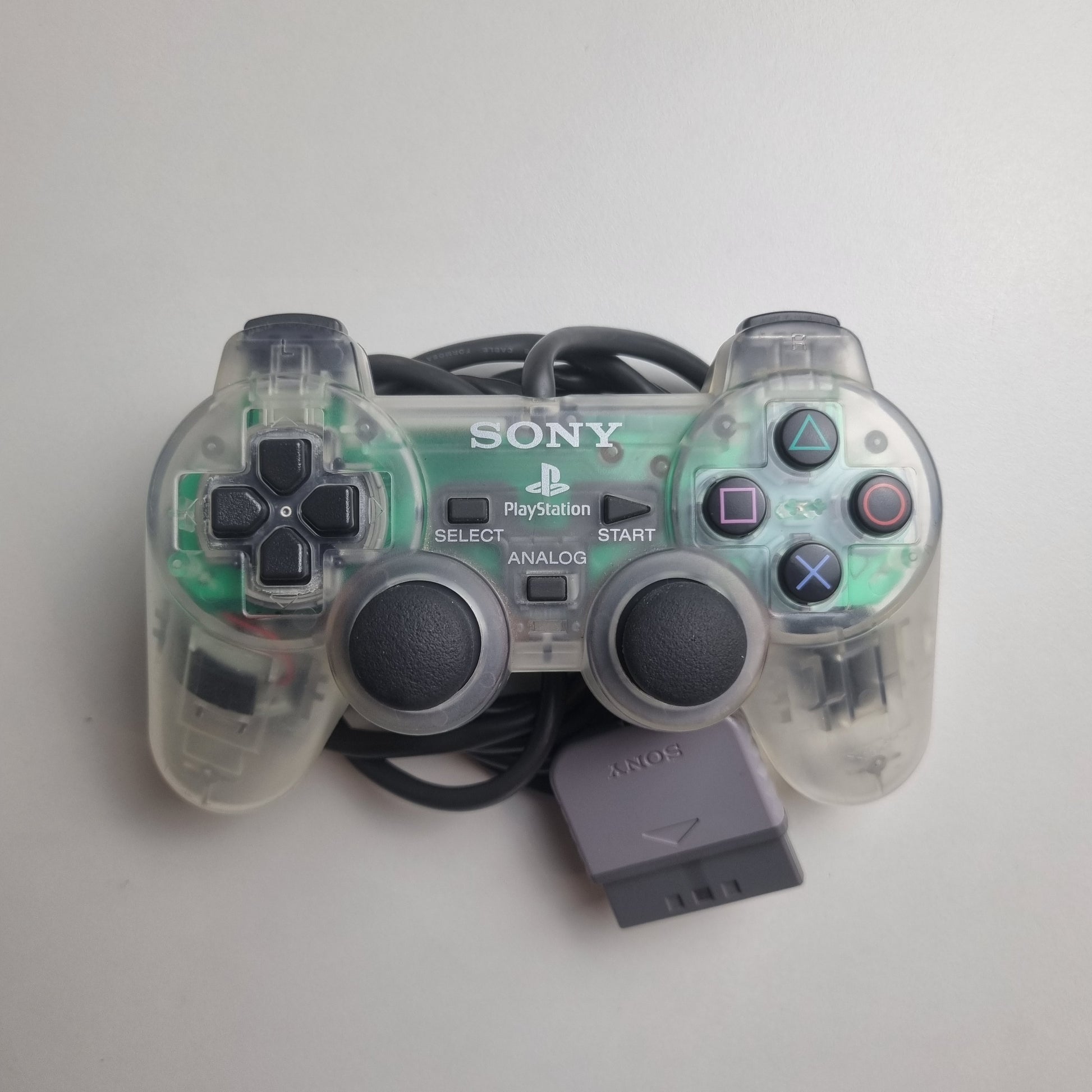 Clear official Sony PlayStation 1 refurbished gaming controller on a light gray background 