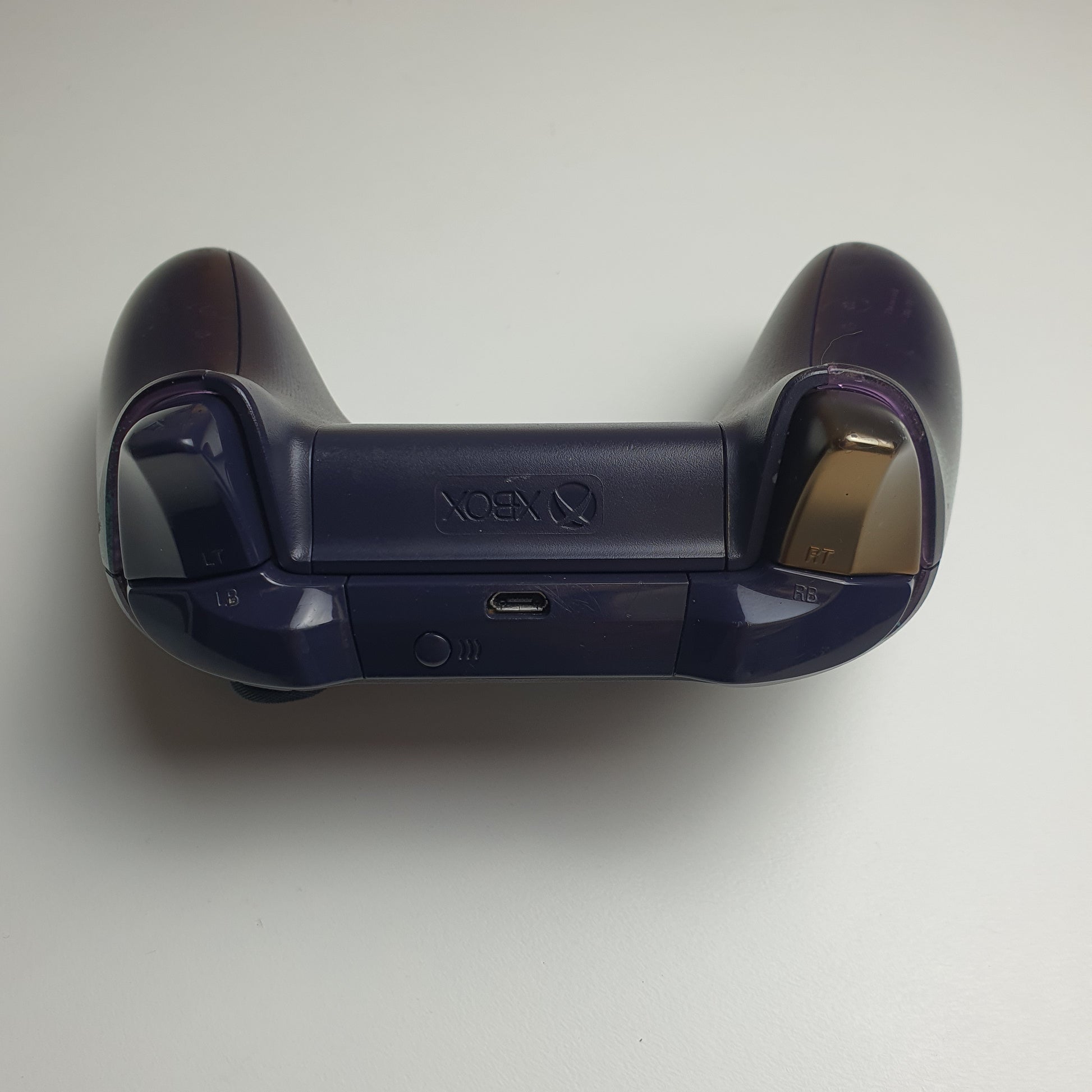 Top of a Xbox One 'Sea of Thieves' controller with gold coloured button on a white background.