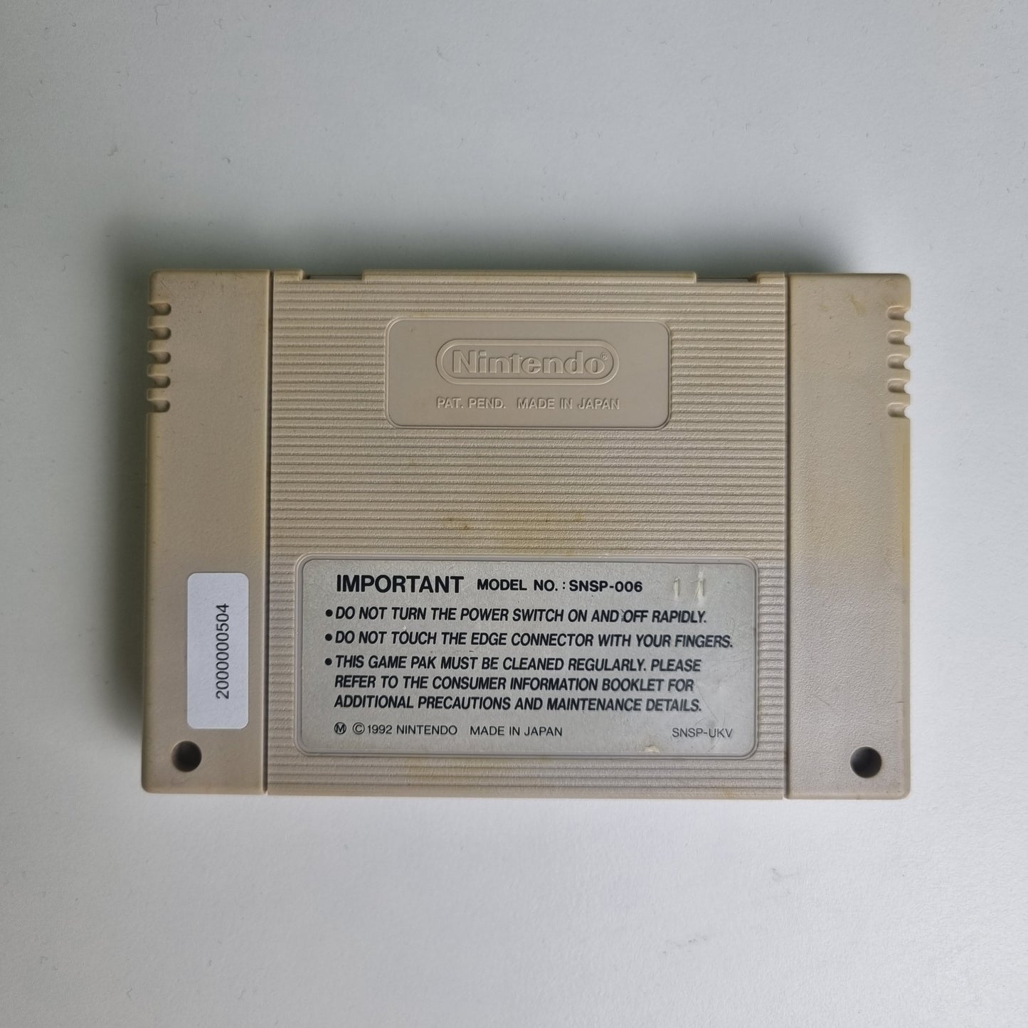 Back of a Super Nintendo game cartridge on a light grey background