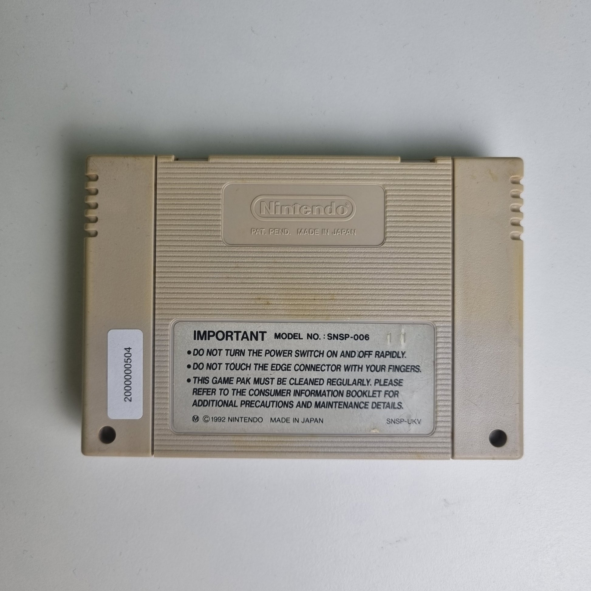 Back of a Super Nintendo game cartridge on a light grey background