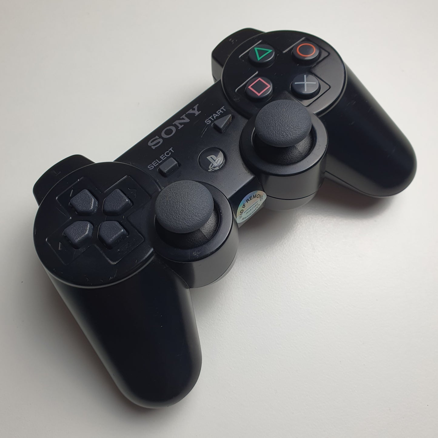 Black PlayStation 3 controller with Sony logo on a white background