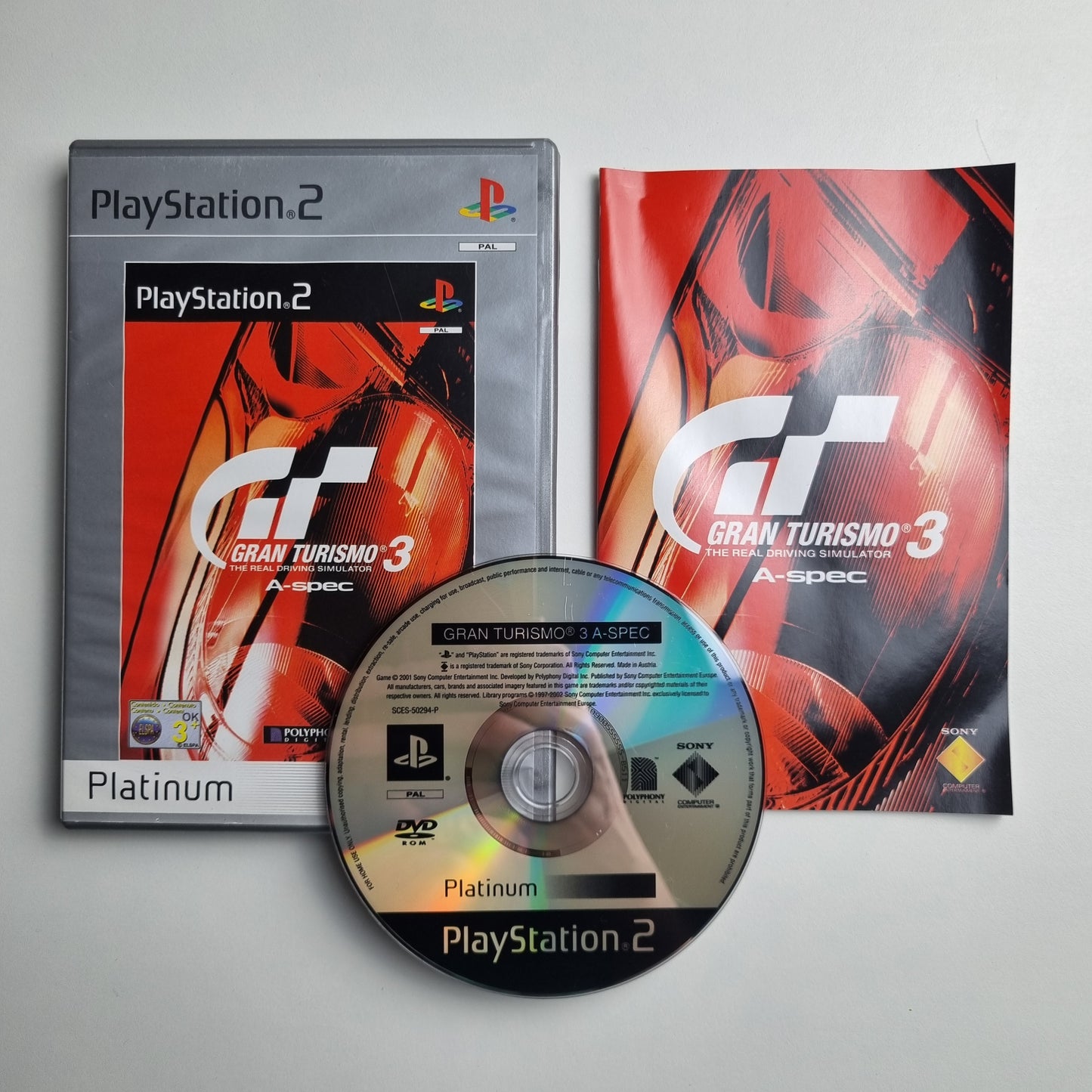 Official Sony PlayStation 2 Platinum pre-loved game titled 'Gran Turismo 3 A-Spec' with packaging and disc on a gray background