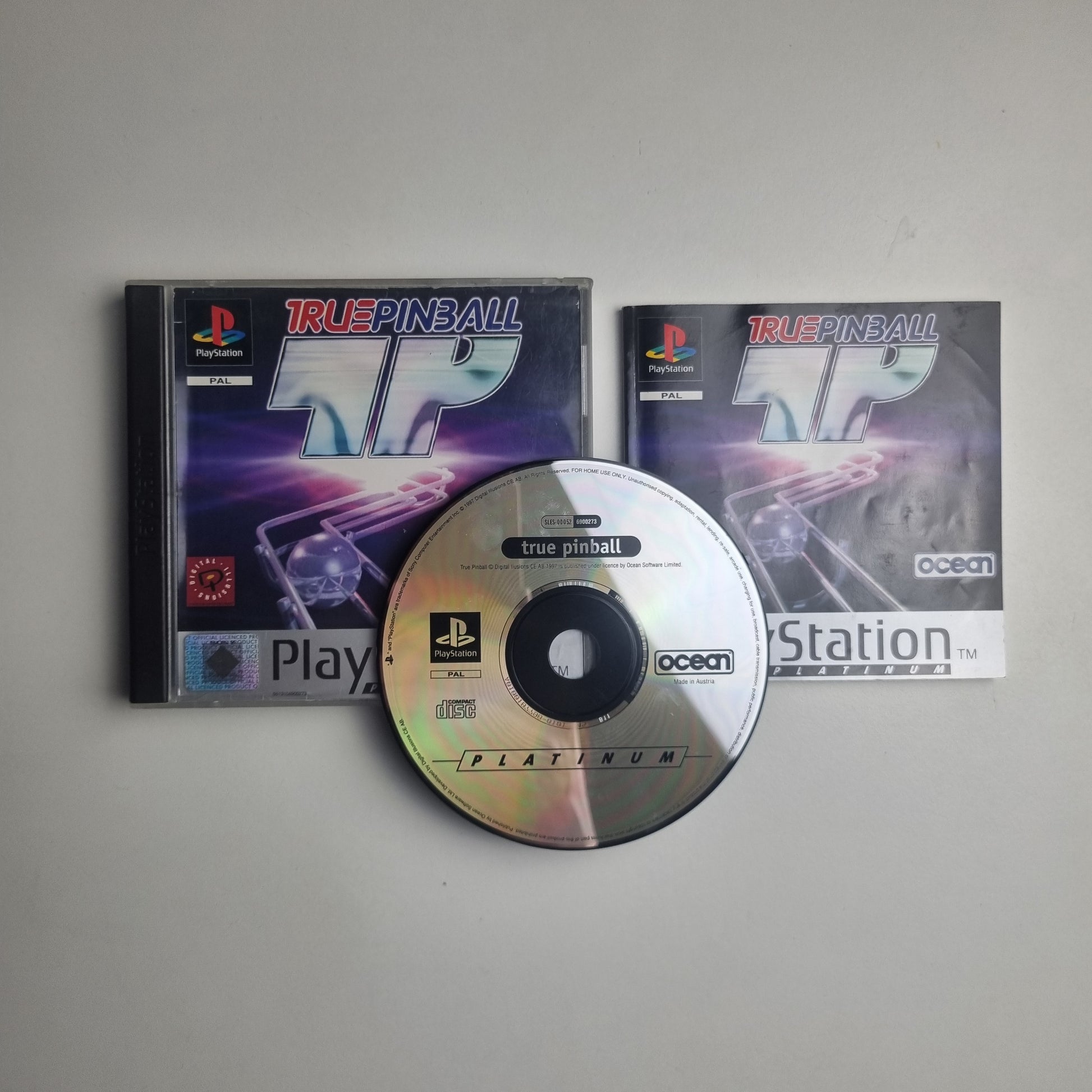 PlayStation PS1 game disc, case and manual for 'True Pinball' on a white background.