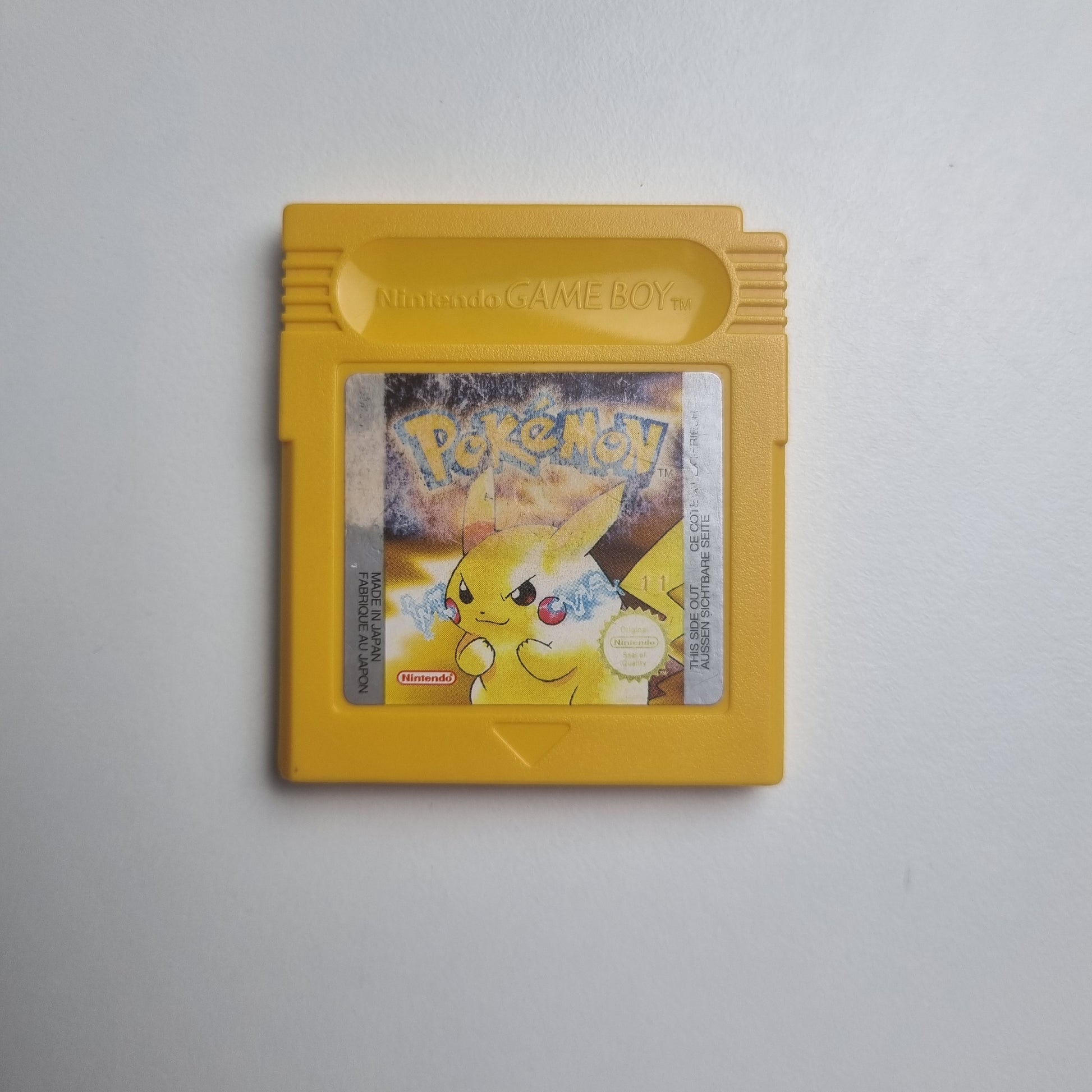 'Pokémon: Yellow Version' video game cartridge for Game Boy showing the character Pikachu. The label has wear from use.