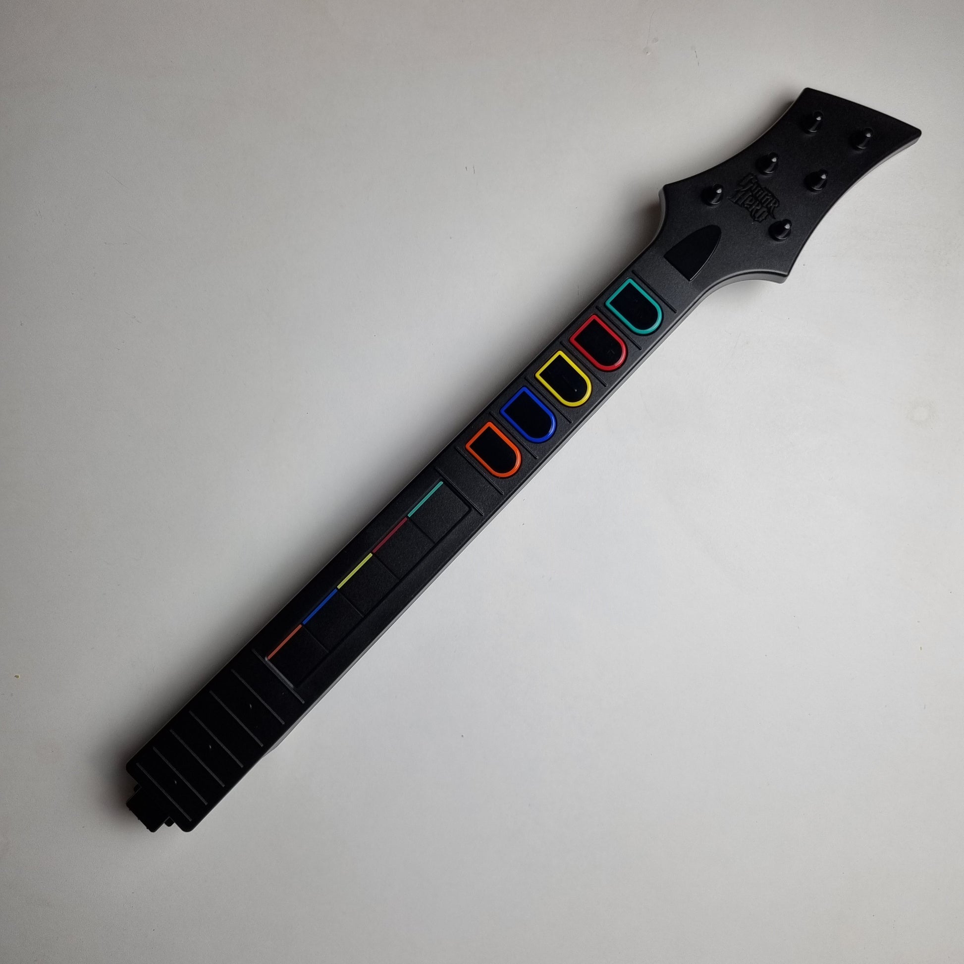 Black neck of a official RedOctane Nintendo Wii guitar controller on a white background.