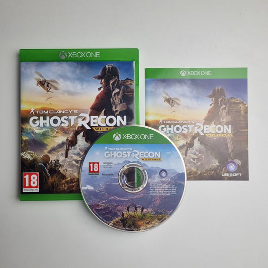 Xbox One game disc, case and insert for 'Tom Clancy's Ghost Recon Wildlands' on a grey background