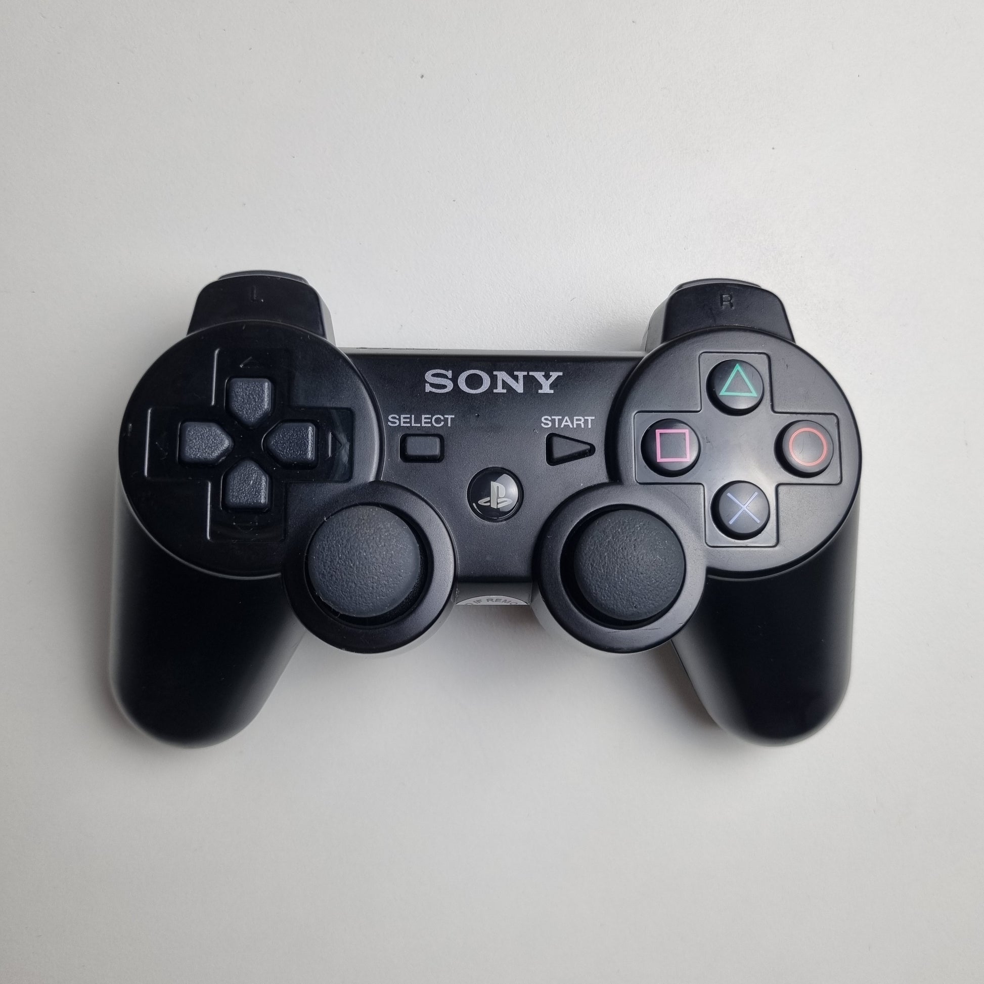 Official Sony PlayStation PS3 SIXAXIS black wireless controller on a white background.