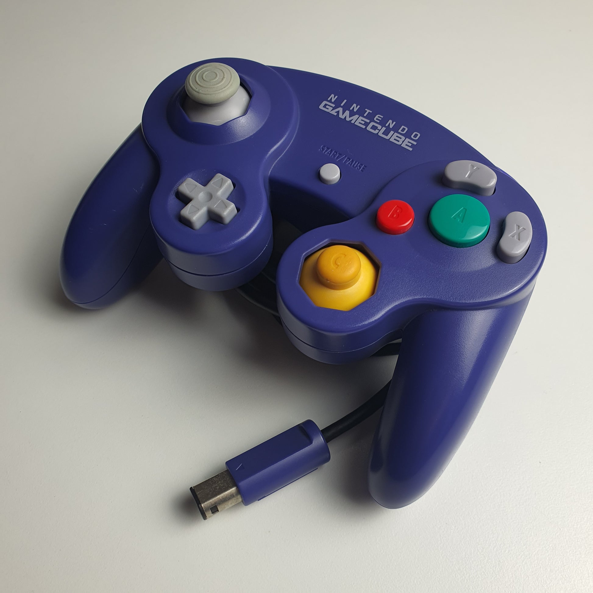 Official indigo Nintendo GameCube controller on a white background.