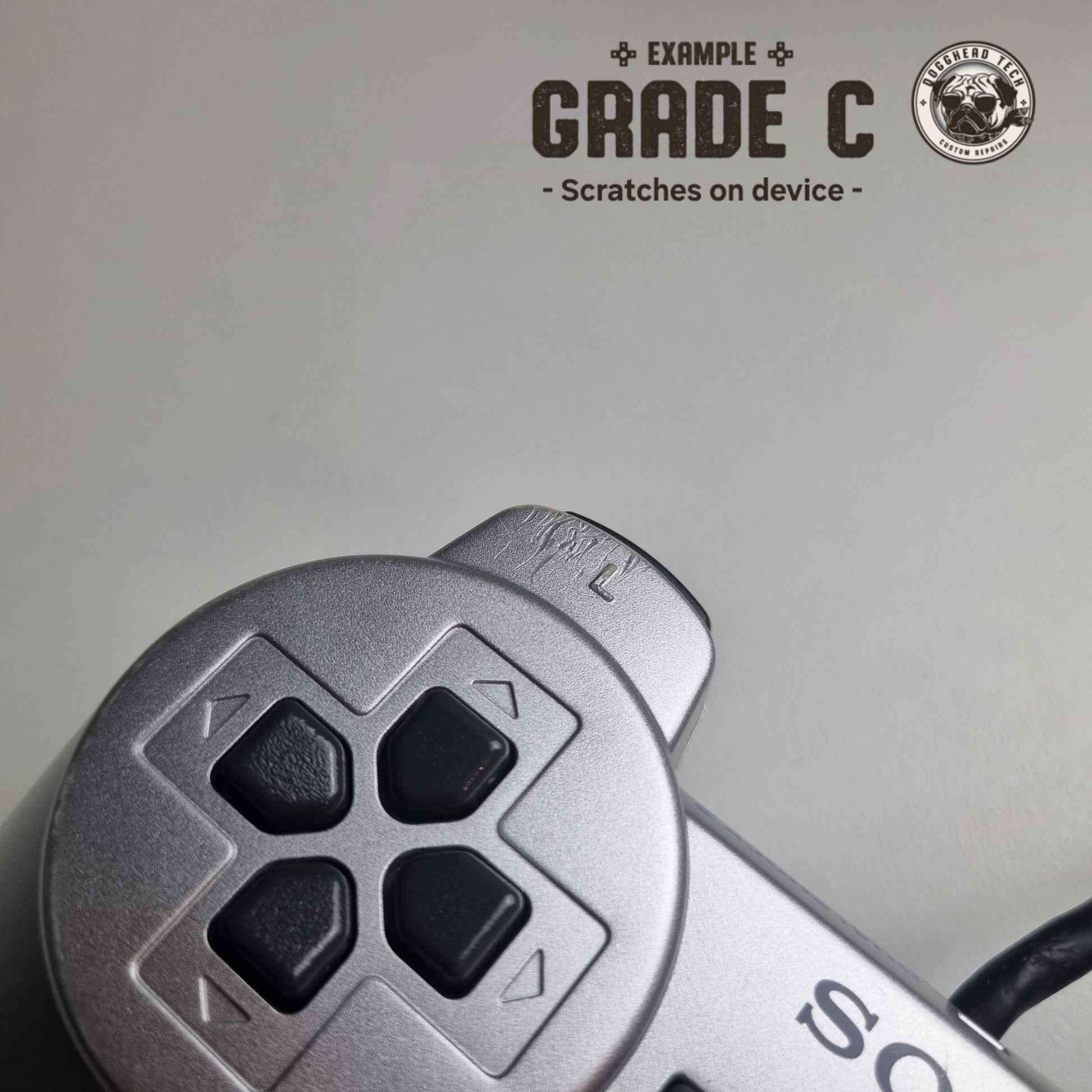 Close-up of some scratches on a refurbished official silver Sony PlayStation 2 wired controller, with the caption 'Grade C: Scratches on device' in the top corner.