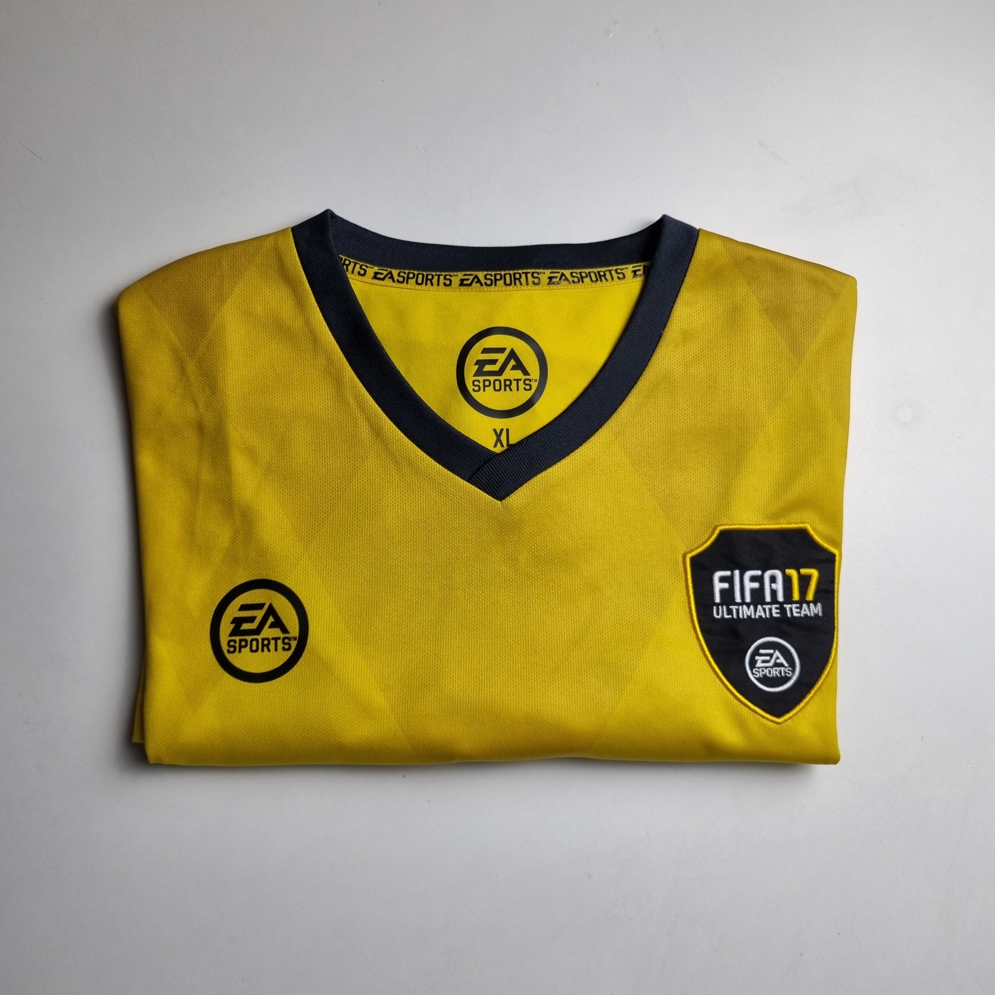 Yellow t-shirt with EA Sports and FIFA logos on a grey background