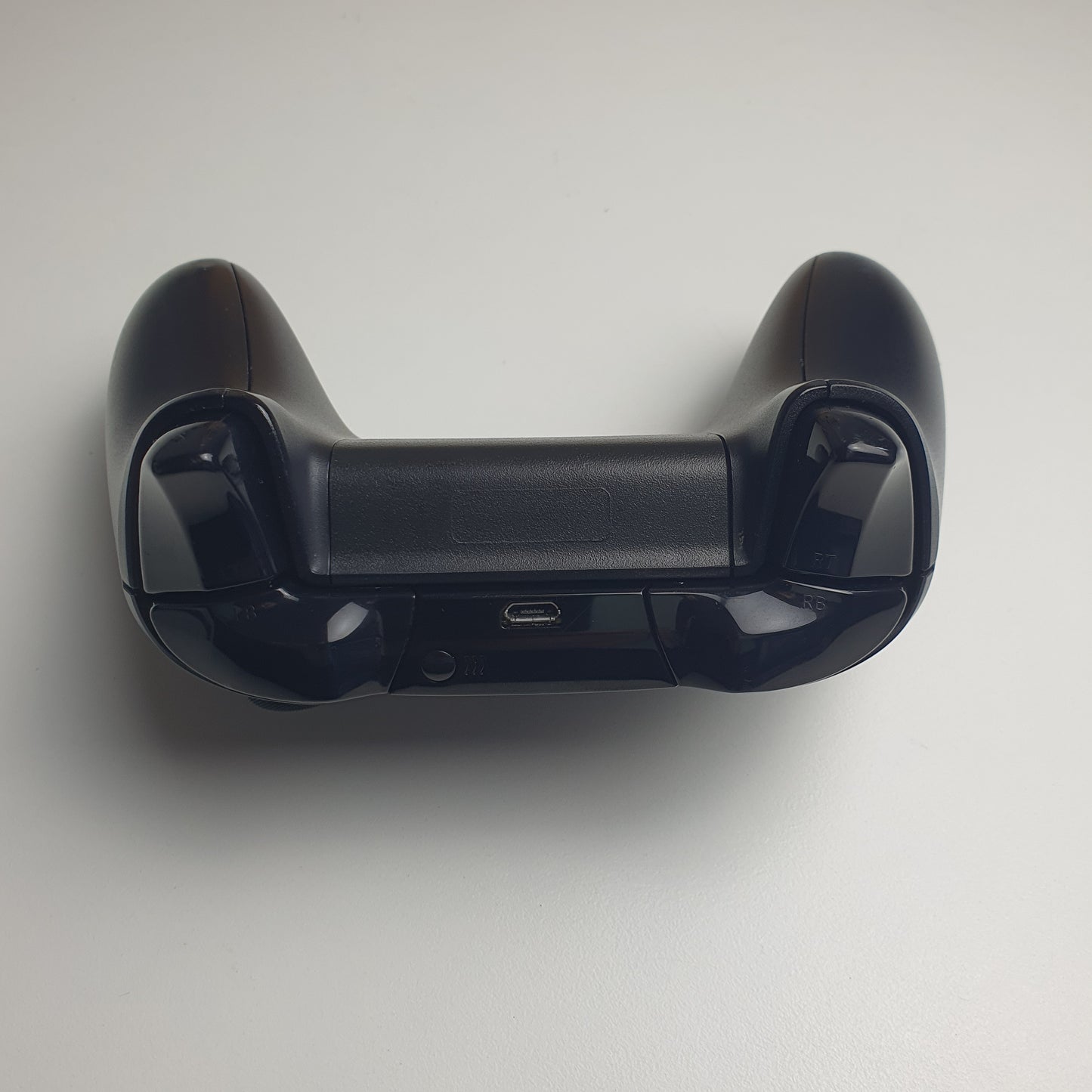 Top of black Xbox One controller on a light grey background