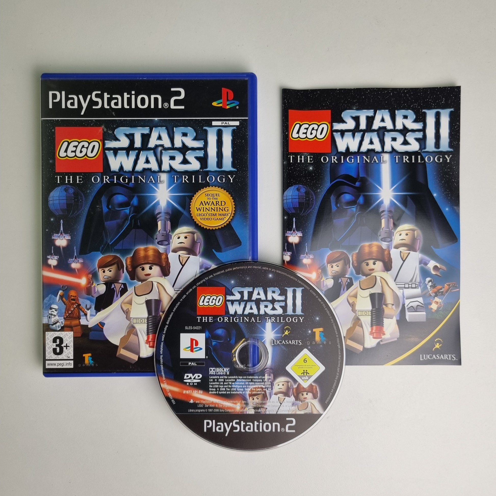 Official Sony PlayStation 2 game case and disc of LEGO Star Wars II on a gray background