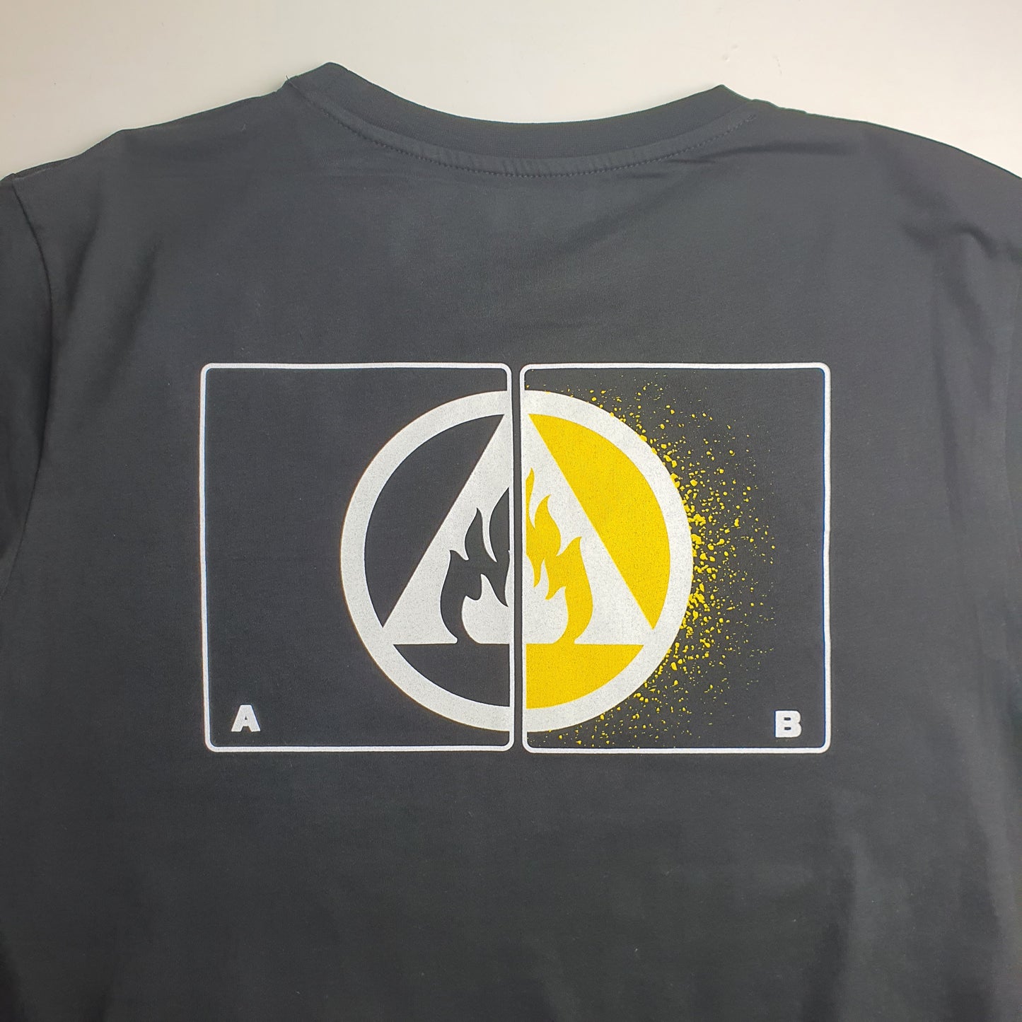 Black sleeveless shirt with a graphic design featuring a yellow circle and a logo on a grey background