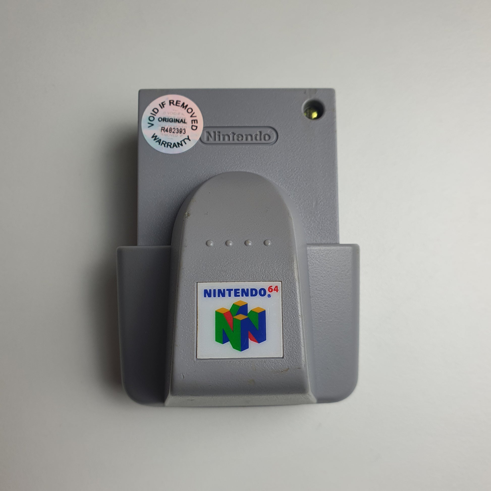 Grey Nintendo 64 N64 rumble pak on a white background 