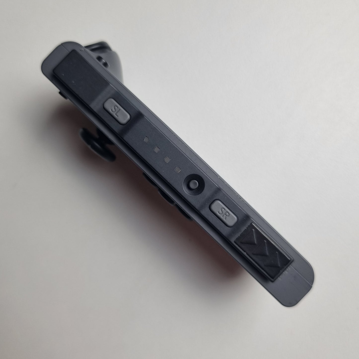 Grey Nintendo Switch Joy-Con, showing the side rail with 'SL' and 'SR' buttons.