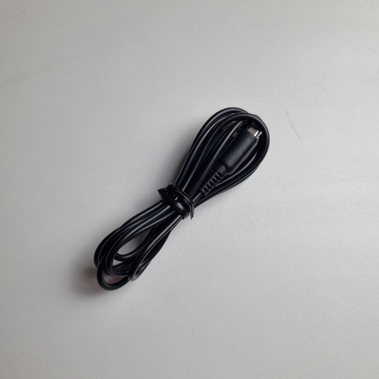 USB black power cord for a Nintendo 2DS on a light grey background
