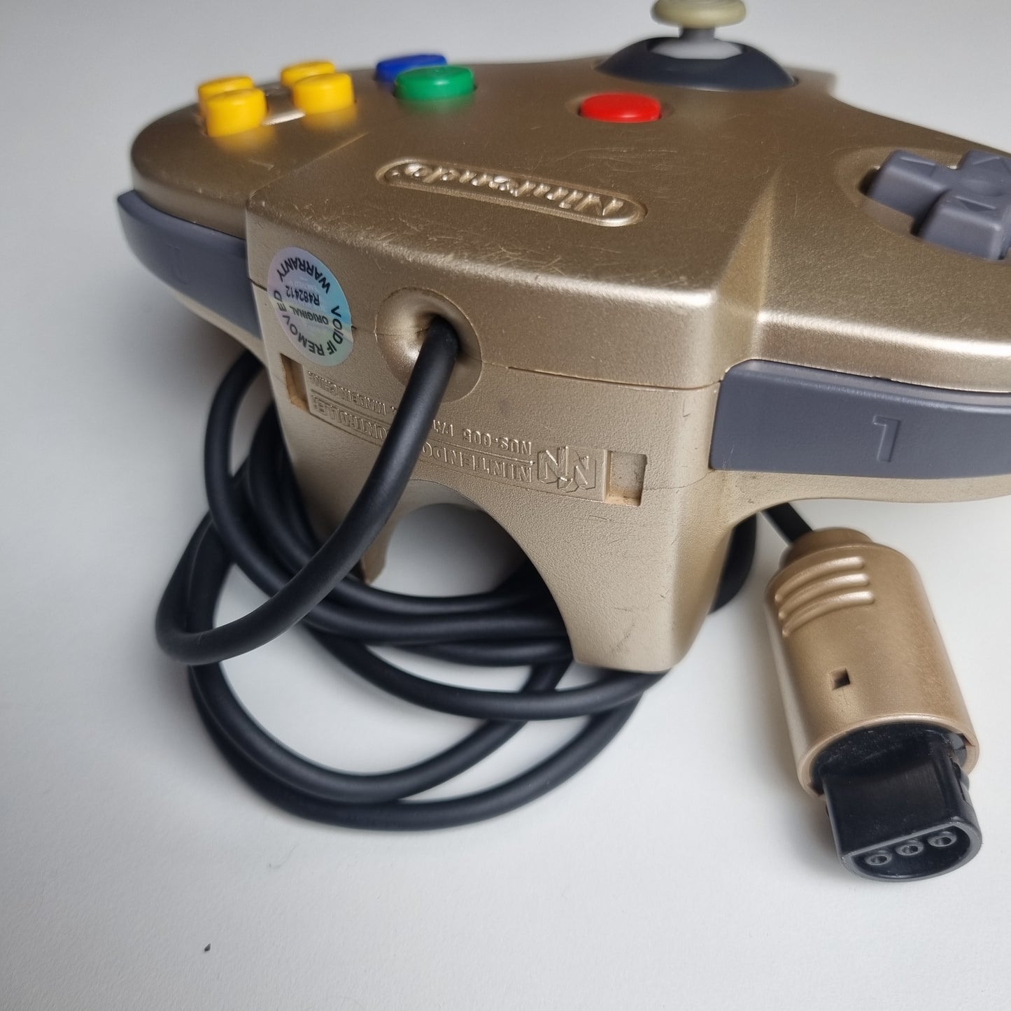 Top of a refurbished modified gold Nintendo 64 controller.