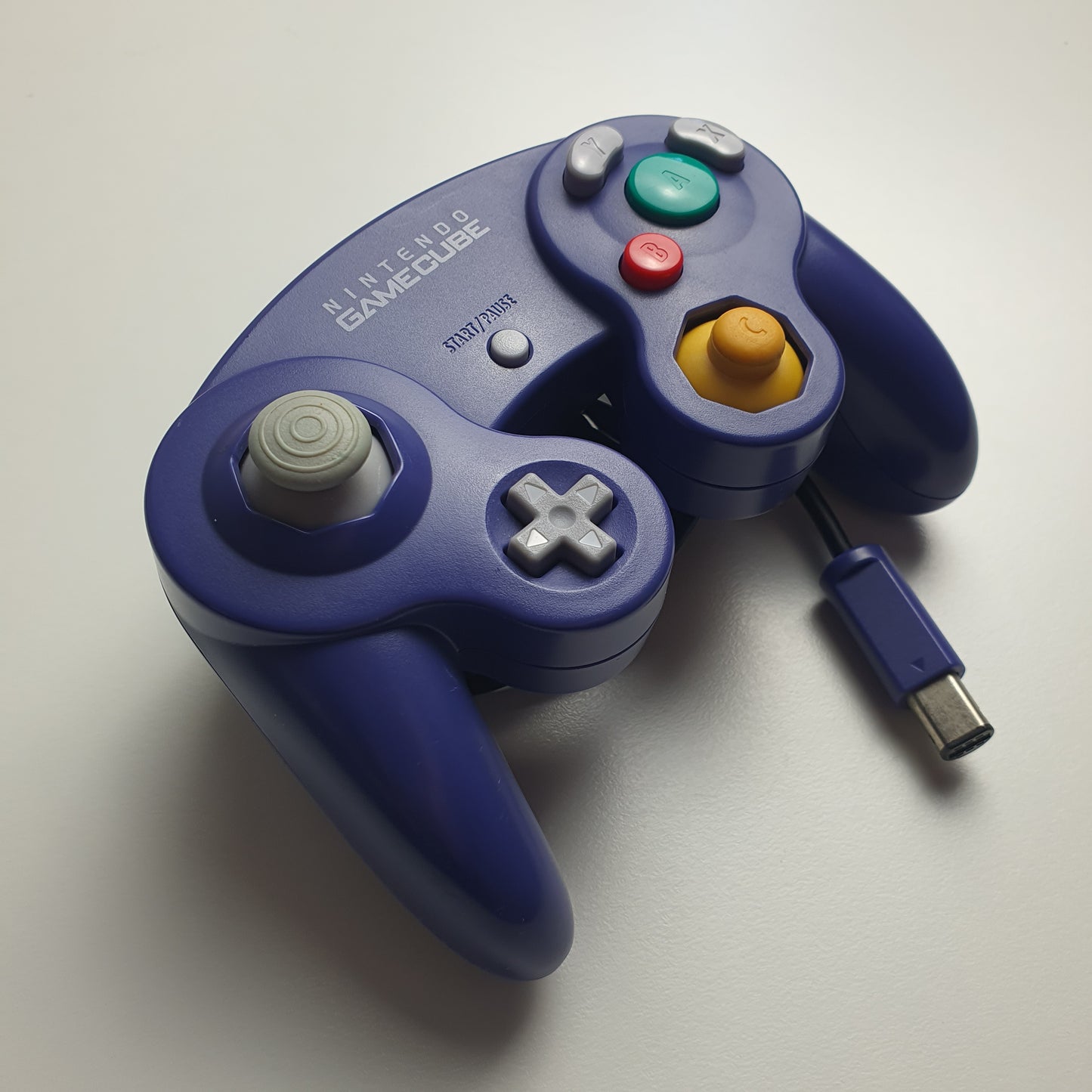 Official indigo Nintendo GameCube controller on a white background.