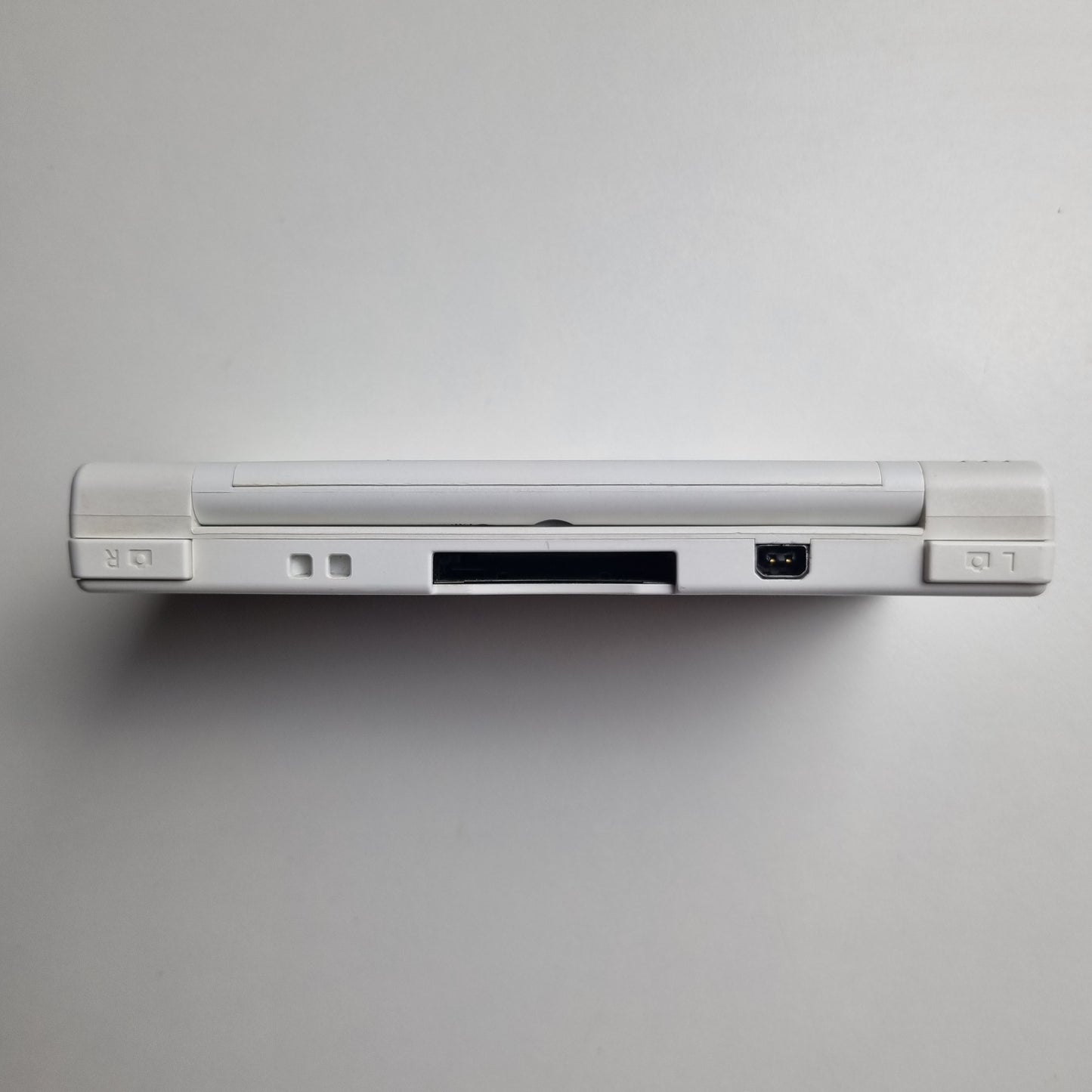 Back of a white Nintendo DSi handheld console on a light grey background.