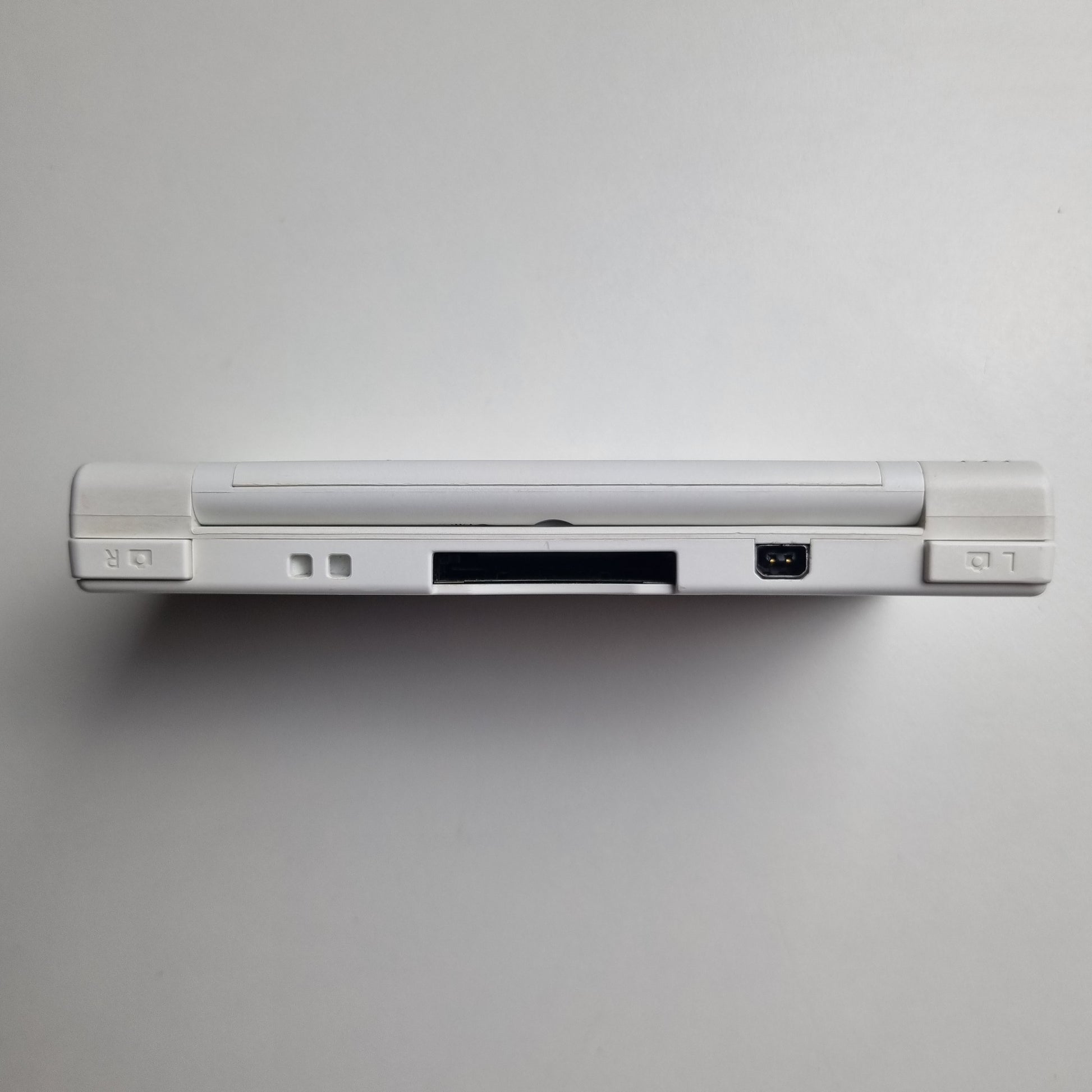 Back of a white Nintendo DSi handheld console on a light grey background.