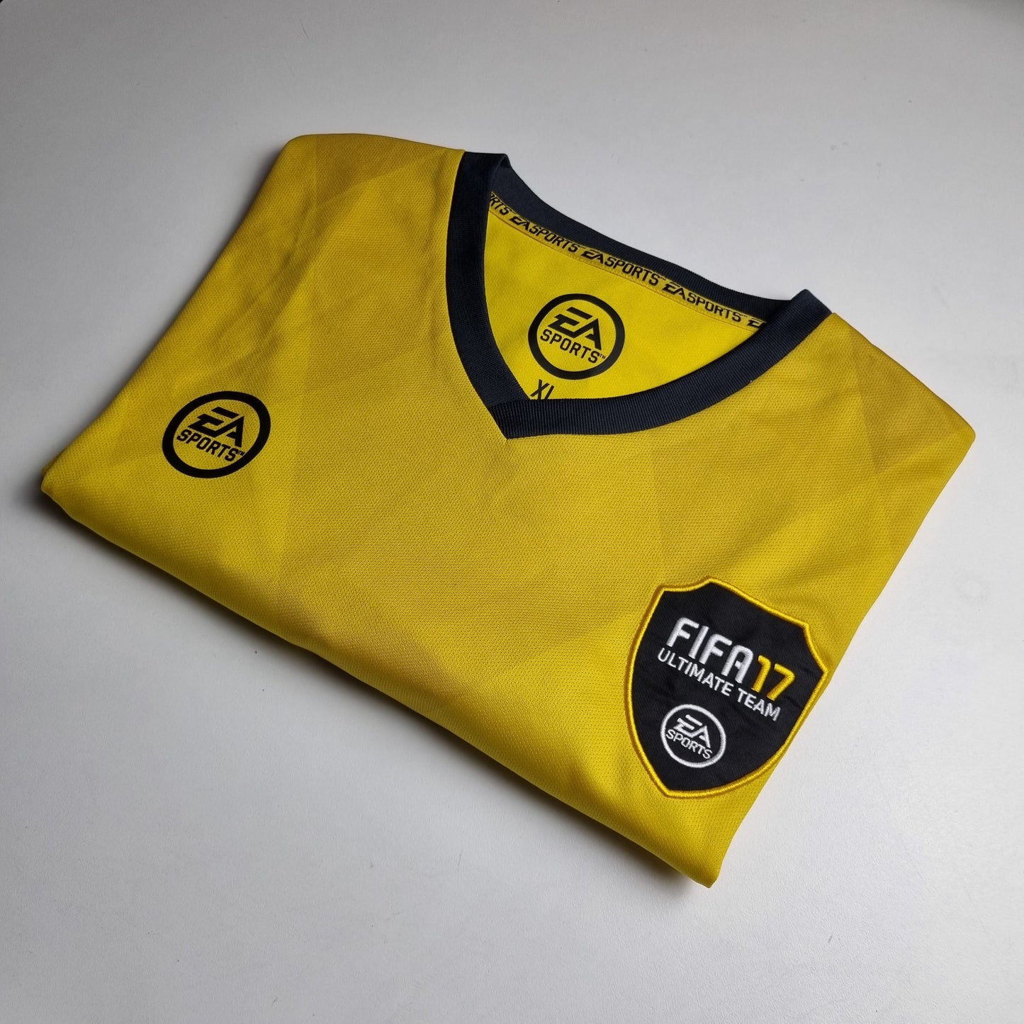 Yellow t-shirt with FIFA 17 Ultimate Team logo on a grey background