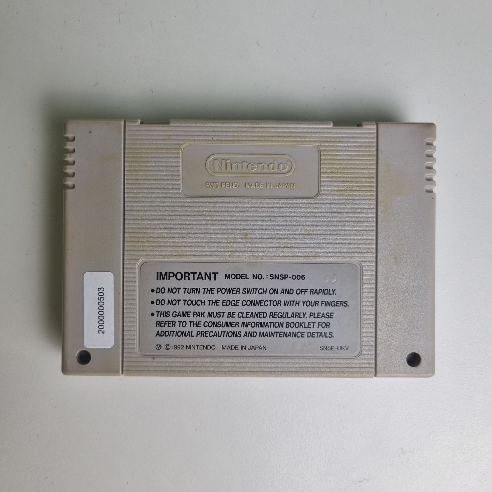 Back of a Super Nintendo game cartridge on a light grey background
