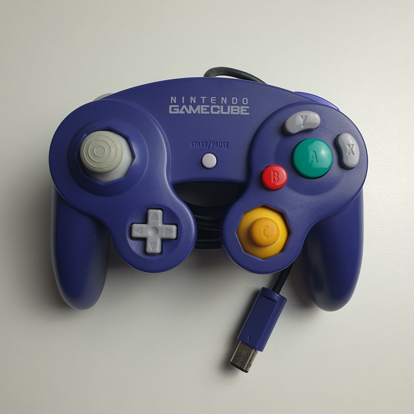 Official indigo Nintendo GameCube controller on a white background.